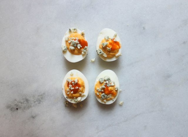 buffalo blue cheese deviled eggs on a marble counter