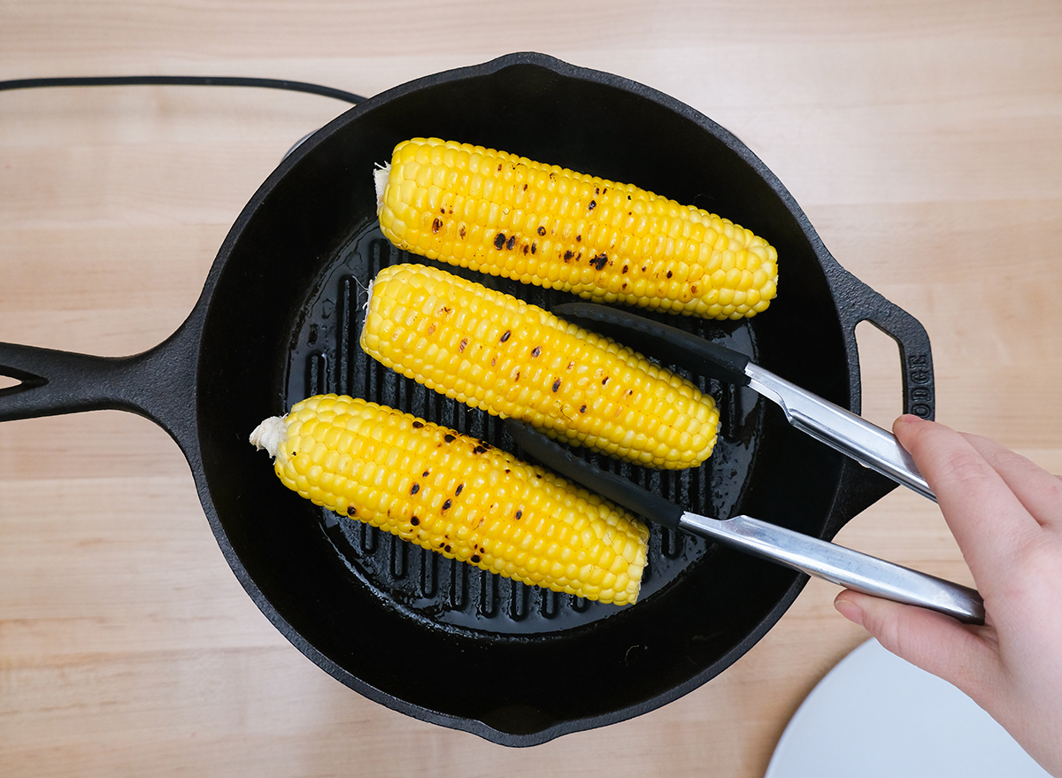 cooking corn on a cast iron grill with oil