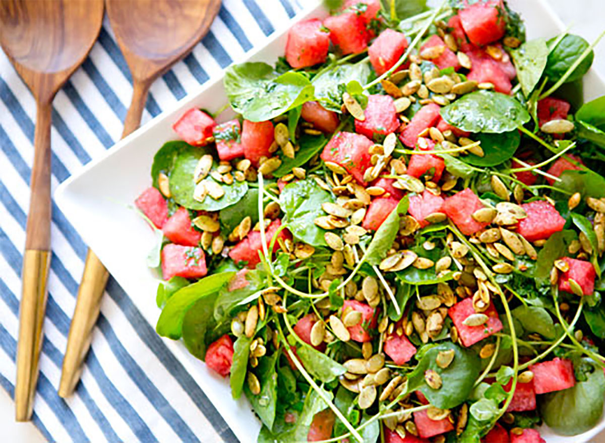summer salad with watermelon and serving tongs
