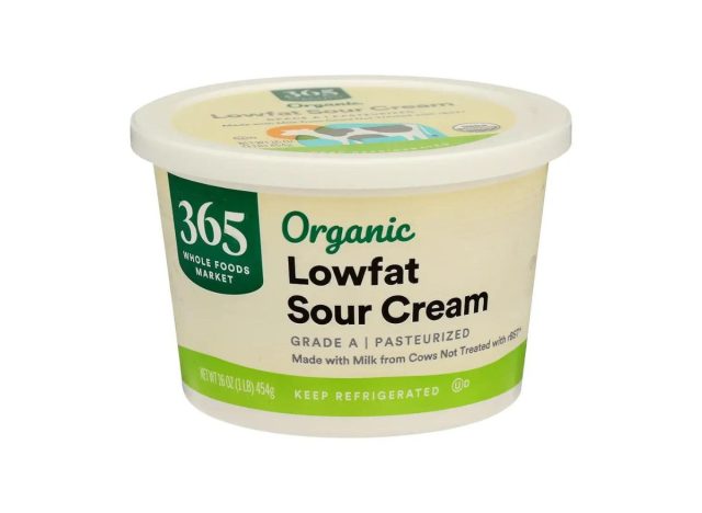 container of Whole Foods sour cream on a white background